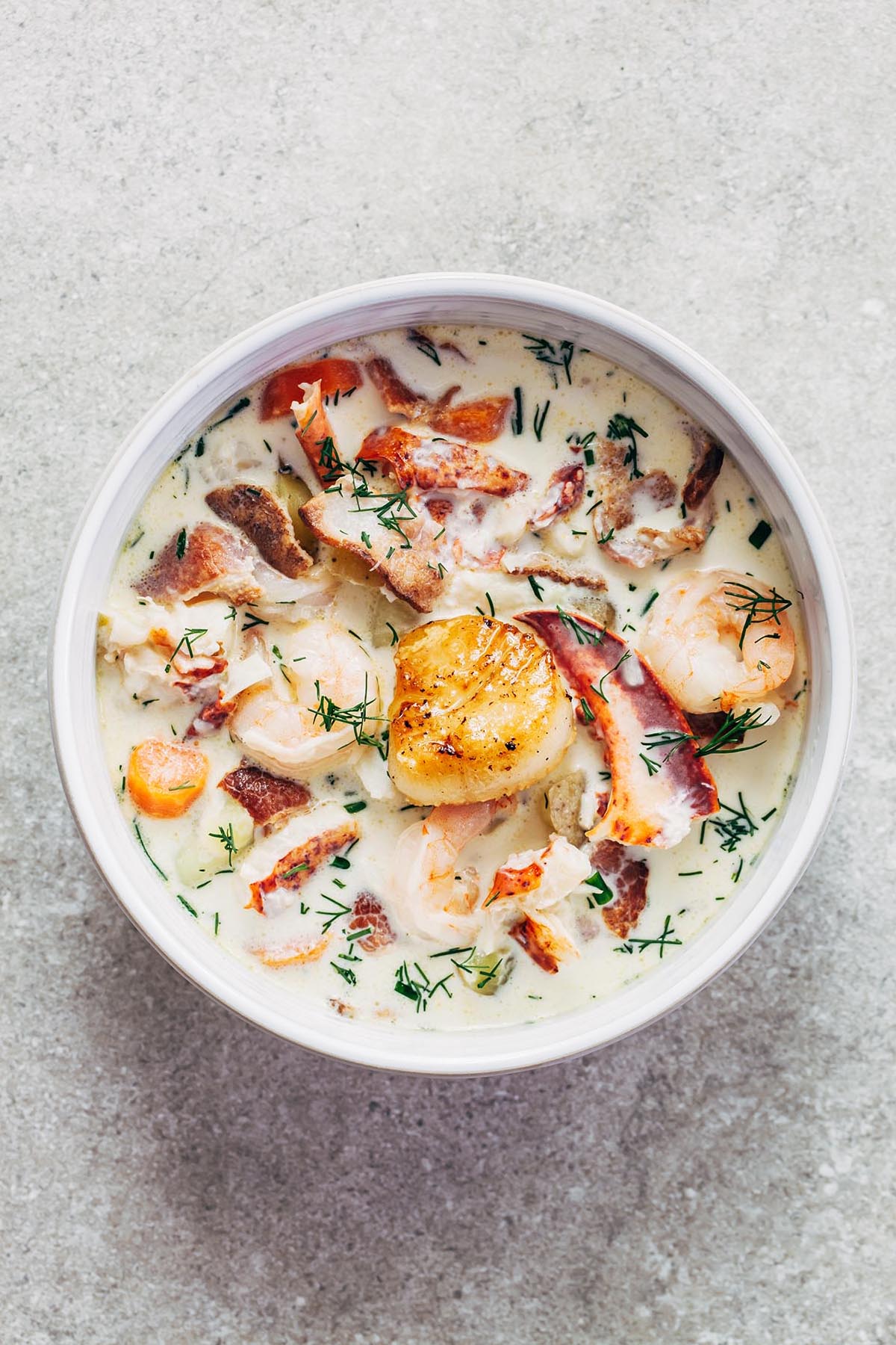 A bowl of Nova Scotia seafood chowder topped with a pan-seared scallop.